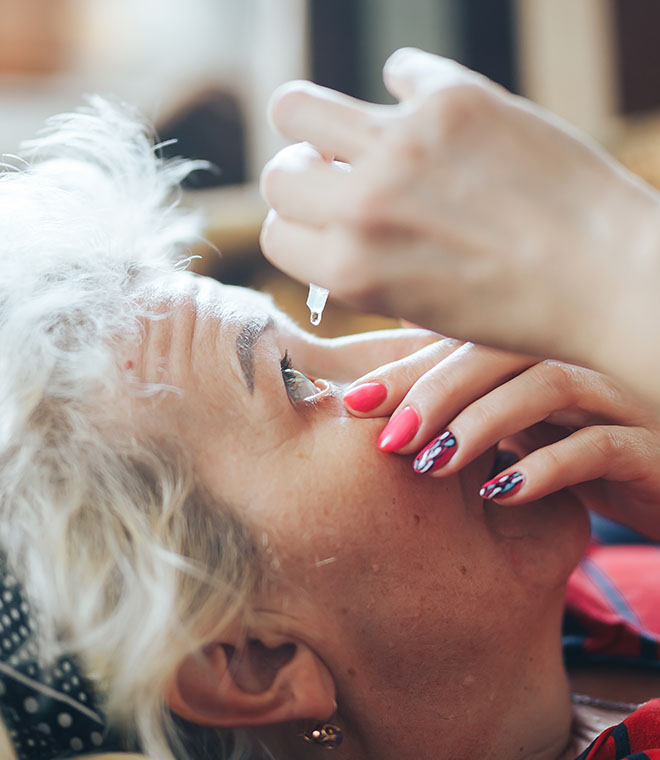 Older woman using eye drops